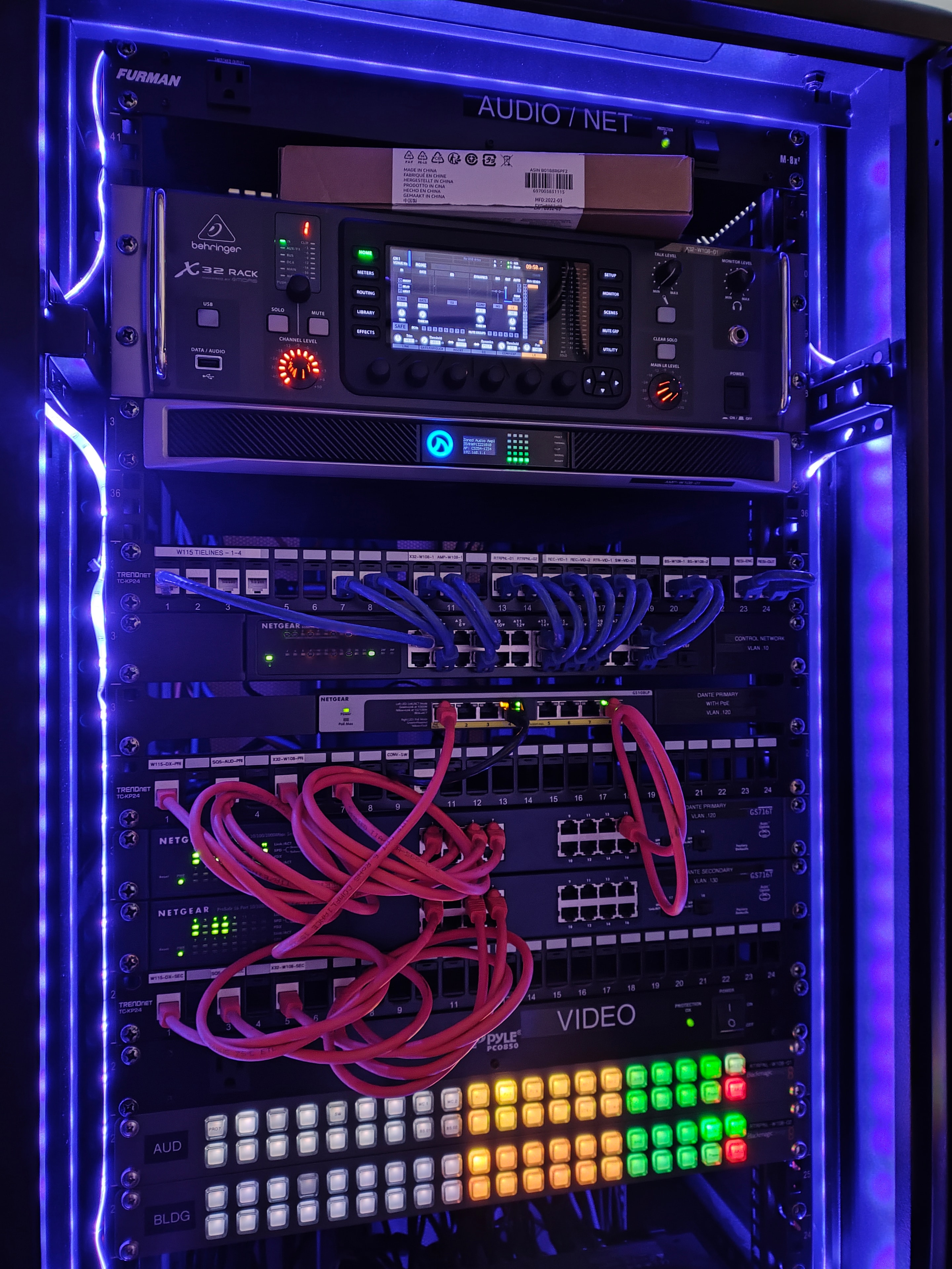AV rack with Behringer X32, Netgear switches, and neon lighting